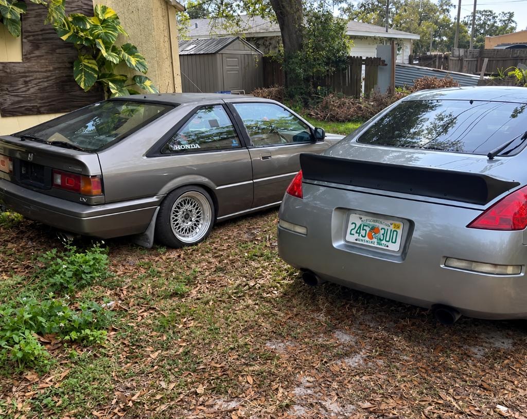 350Z and 86 Honda Accord parked in a yard, rear three-quarter view