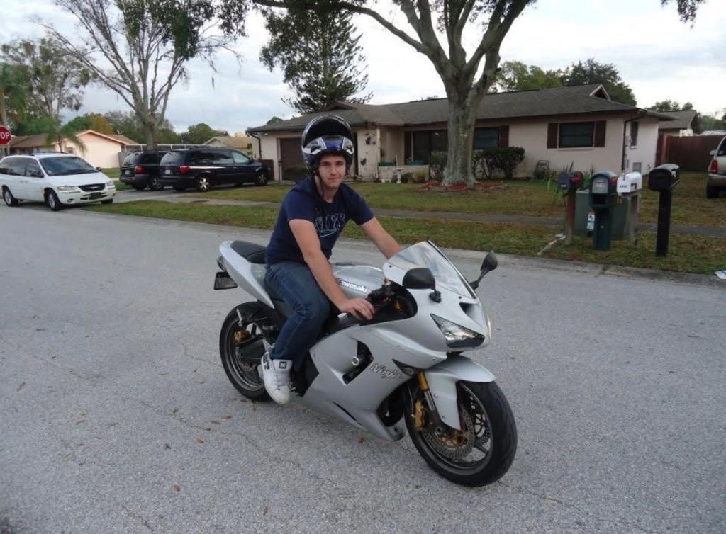 Rider on a white 2005 Kawasaki Ninja 636 in a residential neighborhood — first bike